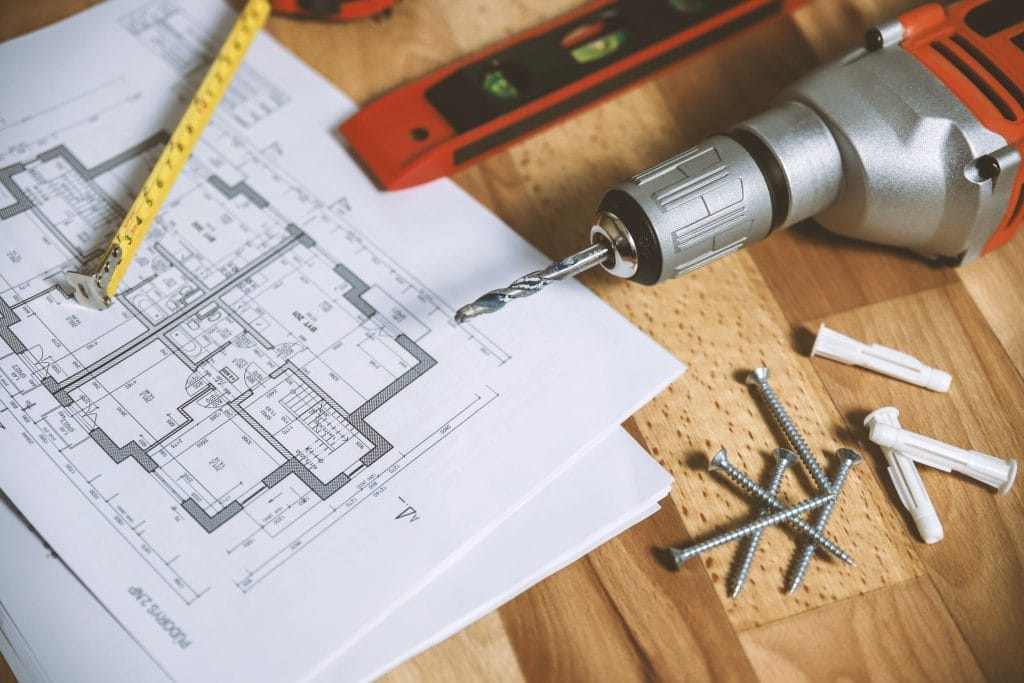 a photo of a drill and a blueprint for a whole home remodel in the portland, oregon area