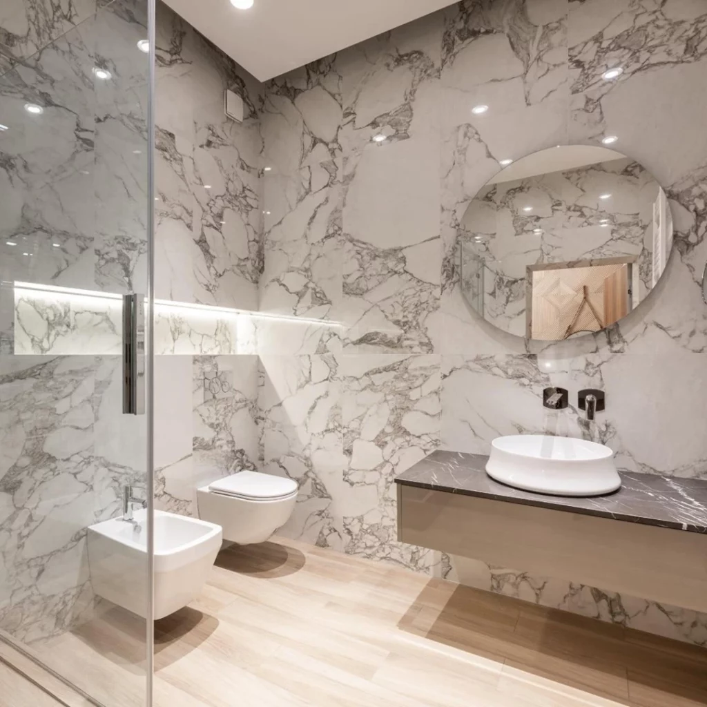 nice modern bathroom with two bidets and marble walls