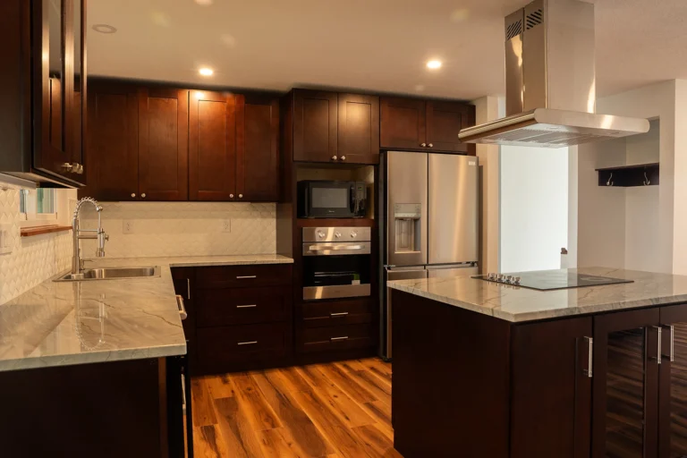 Kitchen renovation highlighting a custom appliance wall with dark wood cabinets and integrated stainless steel ovens.